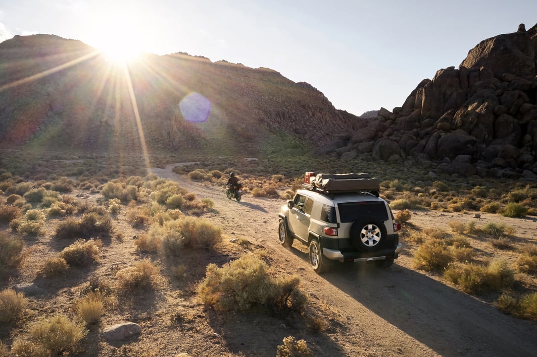 Offroadster and bike on road in semidesert rocky terrain